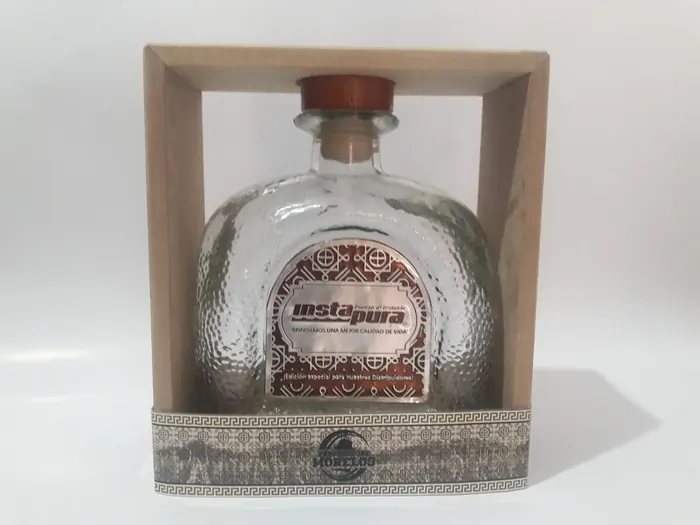 Botella de cristal con placa dentro de un estuche de madera