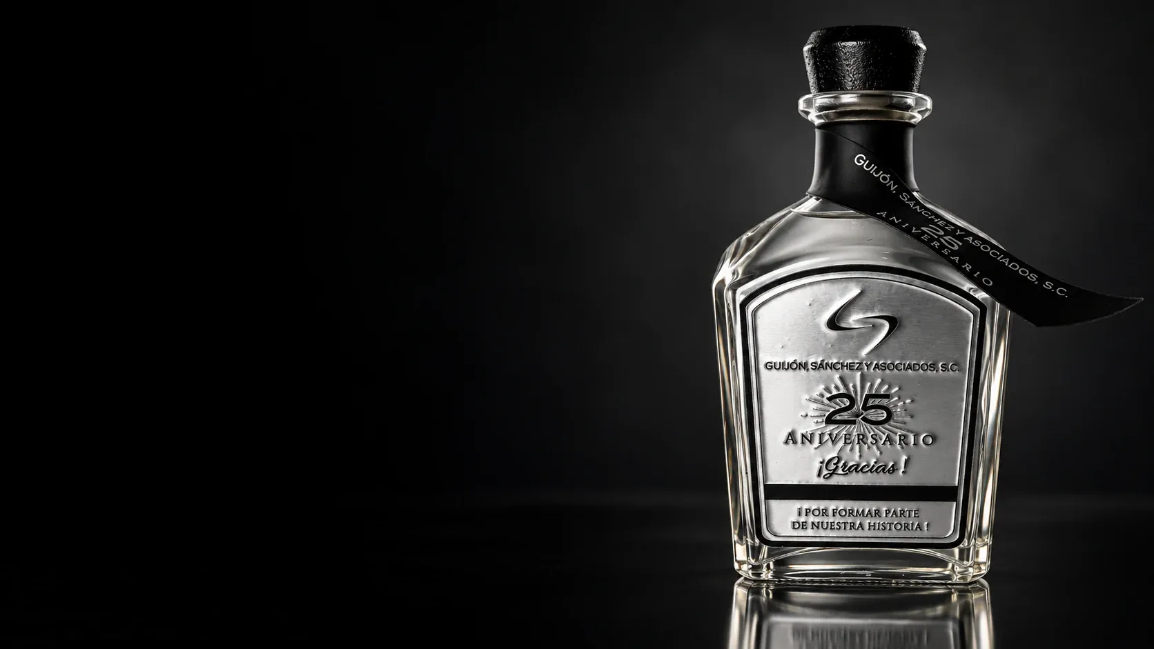 Botella real con placa metálica de agradecimiento y aniversario, presentada con iluminación de estudio
