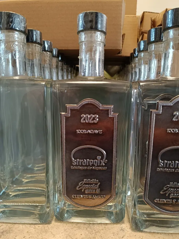 Detalle de placas con identidad corporativa en botellas de un pedido